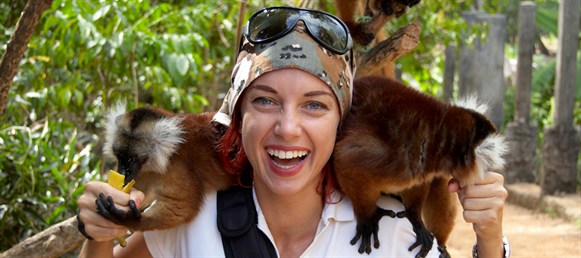 smiling backpacker girl holding a monkey