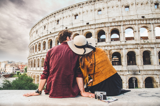 couple of tourists enjoying the view of Colosseum in Rome Italy