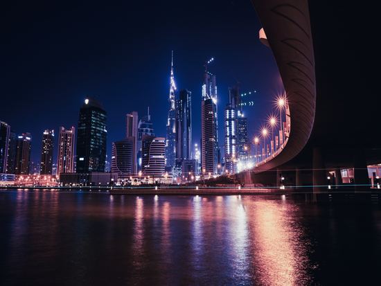 Dubai river and skyscraper buildings at night