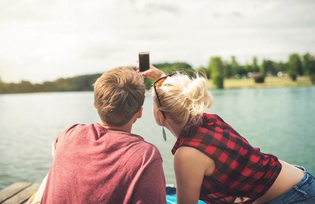 Couple taking a selfie by a lake